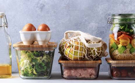glass containers of oil, eggs, lettuce, ground meat, salad, cherries, and a bag of apples